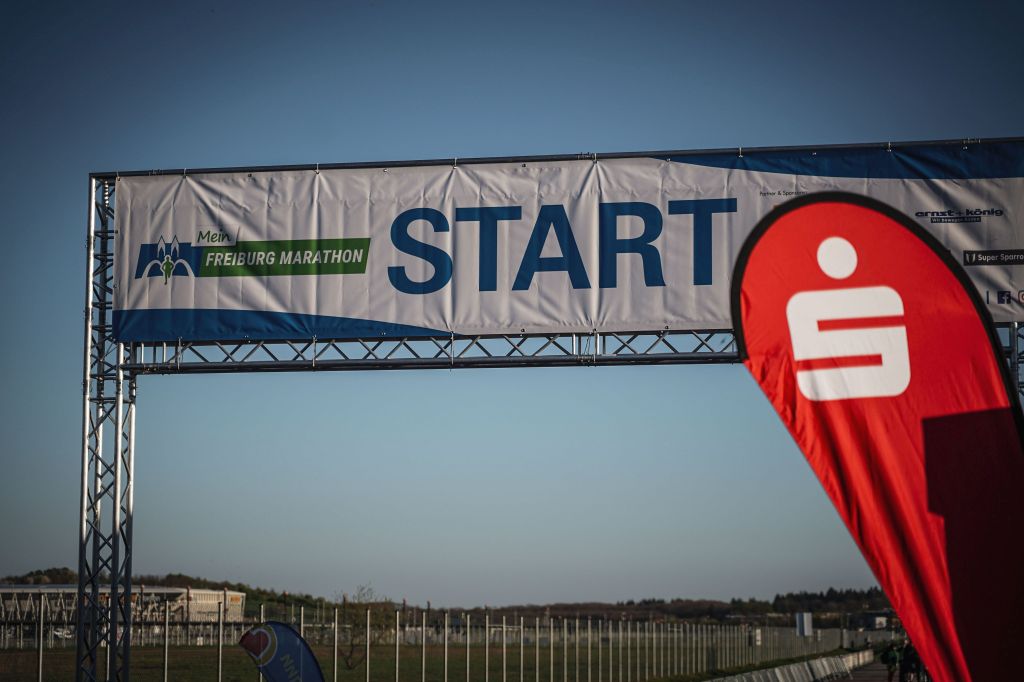 Startbanner beim Freiburgmarathon. Rechts ist ein Werbesegel der Sparkasse zu sehen.